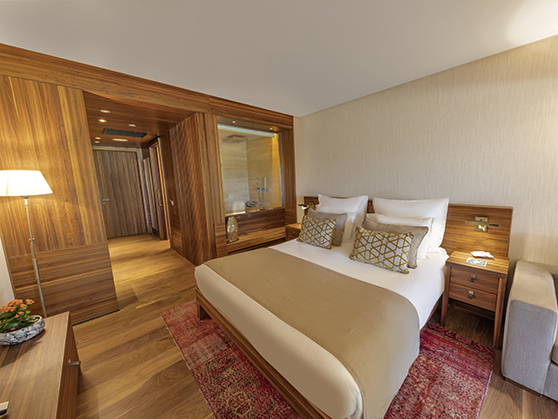 A spacious superior bedroom at D Maris Bay resort. Wooden panelling and neutral textiles contribute to a serene setting for guests to relax in after spending time at the resort. 