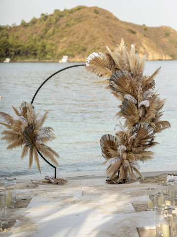 A large display wreath of feathers and corn in front a sea view for a wedding at D Maris Bay.