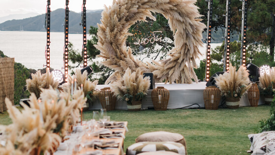 A wedding set up at D Maris Bay, with a large decorative dried wreath, overlooking the sea, 