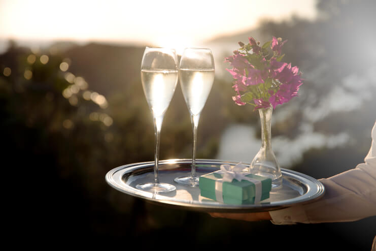  A waiter carries two glasses of champagne and a small jewellery box on a tray as he helps guests create intimate, romantic and unforgettable moments at D Maris Bay resort.